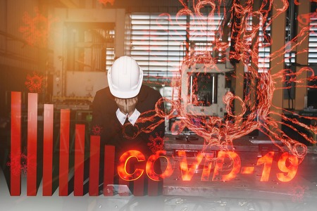 worker sitting with head in hands and a covid-19 graphic 
